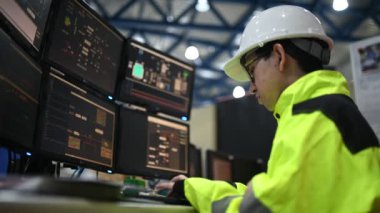 Kontrol odasında çalışan bir mühendis. Yönetici kontrol sistemi. Birçok monitörden teknisyen izleme programı