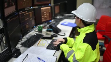 Kontrol odasında çalışan bir mühendis. Yönetici kontrol sistemi. Birçok monitörden teknisyen izleme programı