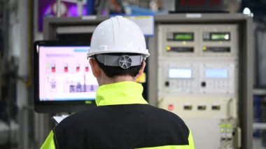 Kontrol odasında çalışan bir mühendis. Yönetici kontrol sistemi. Birçok monitörden teknisyen izleme programı