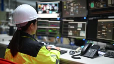 Kontrol odasında çalışan bir mühendis. Yönetici kontrol sistemi. Birçok monitörden teknisyen kadın izleme programı