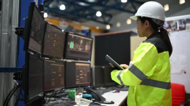 Kontrol odasında çalışan bir mühendis. Yönetici kontrol sistemi. Birçok monitörden teknisyen kadın izleme programı