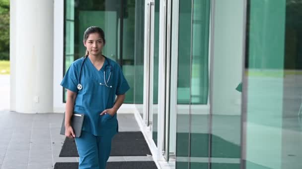 疲れた落ち込んだ女性のアジアのスクラブ看護師は 病院近くのマスクと青い制服を着ています 若い女性医師は懸命な仕事を強調しました — ストック動画