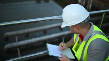 Çevre mühendisi atık su arıtma tesislerinde çalışıyor. Su geri dönüşüm tesisinde tekrar kullanılmak üzere çalışan su tedarik mühendisliği