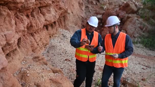 地質学者が私の調査をしています 探検家は鉱物を探すために土壌サンプルを収集する — ストック動画