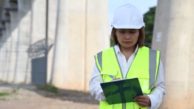 Otoyol köprüsü inşaatında çalışan Asyalı bir kadın mühendis. Sınır ötesi inşaatı denetleyen memur.