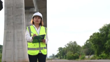 Otoyol köprüsü inşaatında çalışan Asyalı bir kadın mühendis. Sınır ötesi inşaatı denetleyen memur.