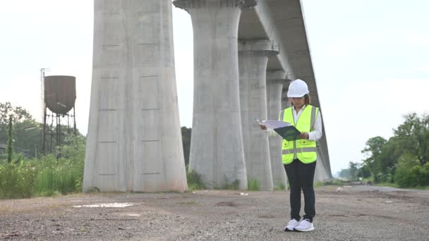 Uma Engenheira Asiática Trabalha Numa Construção Uma Ponte Auto Estrada — Vídeo de Stock