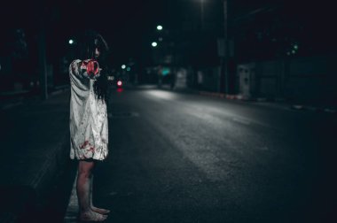 Korkunç kadın konsepti. Şehirdeki yolda bir hayalet var. Şehrin sokaklarında intikamcı bir ruh. Cadılar Bayramı festivali. Makyaj yapan hayalet surat