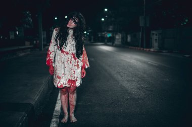 Korkunç kadın konsepti. Şehirdeki yolda bir hayalet var. Şehrin sokaklarında intikamcı bir ruh. Cadılar Bayramı festivali. Makyaj yapan hayalet surat
