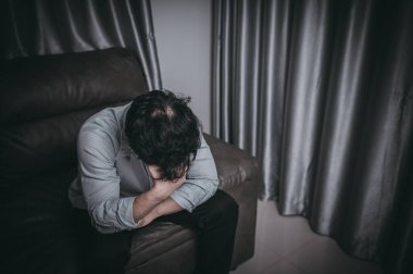 Asyalı yakışıklı adam aşırı iş yükünden dolayı stresli. Yorgun erkek, şirketten bir sürü iş ve depresyon riskinden sonra eve döner.