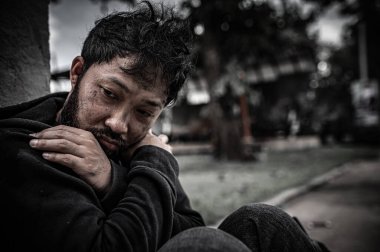 Asyalı adam yan yolda evsiz. Bir yabancı, ailesi olmadığı için yolda tek başına yaşamak zorundadır..