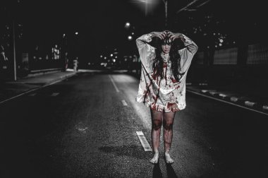 Korkunç kadın konsepti. Şehirdeki yolda bir hayalet var. Şehrin sokaklarında intikamcı bir ruh. Cadılar Bayramı festivali. Makyaj yapan hayalet surat