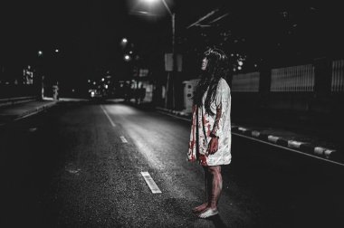 Korkunç kadın konsepti. Şehirdeki yolda bir hayalet var. Şehrin sokaklarında intikamcı bir ruh. Cadılar Bayramı festivali. Makyaj yapan hayalet surat