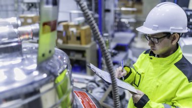 Ameliyathanede çalışan Asyalı mühendis. Taylandlılar kask takar. Çalışkanlık ve sabırla çalıştı, hidrojen tankındaki kapakçık düzenleyicisini kontrol etti..