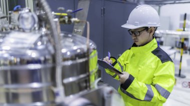 Ameliyathanede çalışan Asyalı mühendis. Taylandlılar kask takar. Çalışkanlık ve sabırla çalıştı, hidrojen tankındaki kapakçık düzenleyicisini kontrol etti..