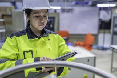 Ameliyathanede çalışan Asyalı mühendis. Taylandlılar kask takar. Adam özenle ve sabırla çalışmış, kadın hidrojen tankındaki valf düzenleyicisini kontrol etmiş..