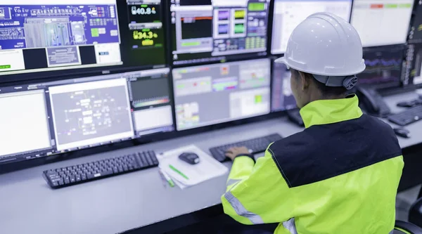 Kontrol odasında çalışan bir mühendis. Yönetici kontrol sistemi. Birçok monitörden teknisyen izleme programı