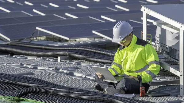 Asian engineer working at Floating solar power plant. Renewable energy. Technician and investor solar panels checking the panels at solar energy installation