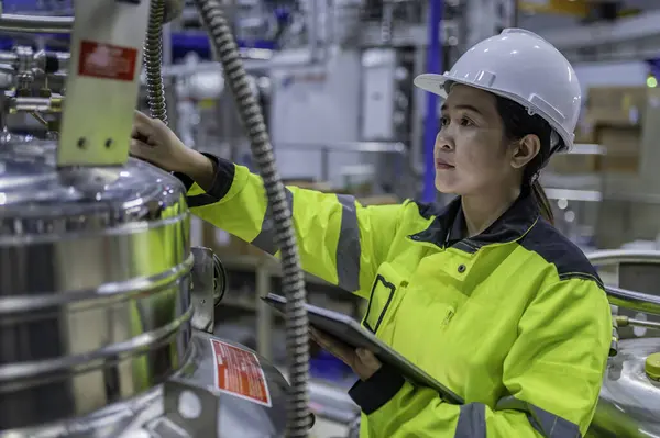 Ameliyathanede çalışan Asyalı mühendis. Taylandlılar kask takar. Adam özenle ve sabırla çalışmış, kadın hidrojen tankındaki valf düzenleyicisini kontrol etmiş..
