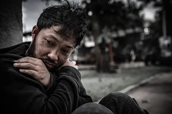 Asyalı adam yan yolda evsiz. Bir yabancı, ailesi olmadığı için yolda tek başına yaşamak zorundadır..