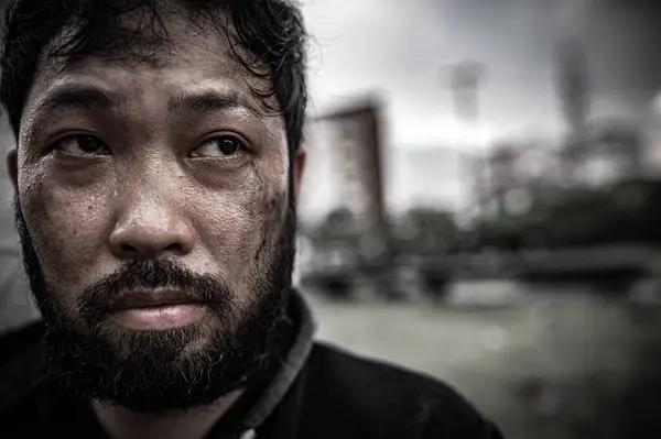 Asyalı adam yan yolda evsiz. Bir yabancı, ailesi olmadığı için yolda tek başına yaşamak zorundadır..