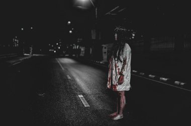 Korkunç kadın konsepti. Şehirdeki yolda bir hayalet var. Şehrin sokaklarında intikamcı bir ruh. Cadılar Bayramı festivali. Makyaj yapan hayalet surat