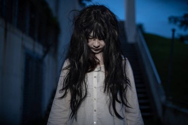 Asyalı kadın portresi kanla kaplanmış hayalet yüzü. Korku sahnesi. Ürkütücü bir geçmiş. Cadılar Bayramı posteri. Taylandlılar.