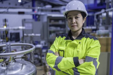 Ameliyathanede çalışan Asyalı mühendis. Taylandlılar kask takar. Adam özenle ve sabırla çalışmış, kadın hidrojen tankındaki valf düzenleyicisini kontrol etmiş..