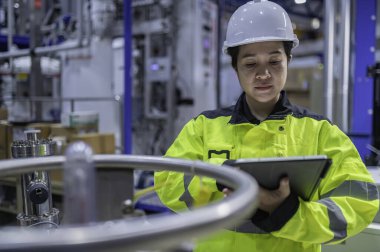 Ameliyathanede çalışan Asyalı mühendis. Taylandlılar kask takar. Adam özenle ve sabırla çalışmış, kadın hidrojen tankındaki valf düzenleyicisini kontrol etmiş..