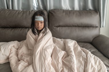 Küçük Asyalı kız evde hasta. Okuldan gelen gripten hasta.