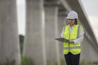 Otoyol köprüsü inşaatında çalışan Asyalı bir kadın mühendis. Sınır ötesi inşaatı denetleyen memur.