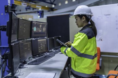 Büyük Endüstri Fabrikası Kadın Bilgisayar Mühendisi Kişisel Bilgisayar 'da çalışıyor. Kontrol makinesi için program kodluyor. Taylandlılar dört monitörle çalışıyorlar. Ciddi ile çalışan programcı