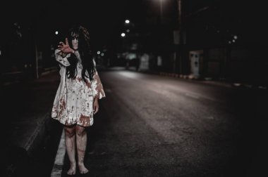 Korkunç kadın konsepti. Şehirdeki yolda bir hayalet var. Şehrin sokaklarında intikamcı bir ruh. Cadılar Bayramı festivali. Makyaj yapan hayalet surat