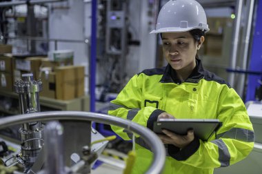 Ameliyathanede çalışan Asyalı mühendis. Taylandlılar kask takar. Adam özenle ve sabırla çalışmış, kadın hidrojen tankındaki valf düzenleyicisini kontrol etmiş..