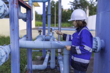 Çevre mühendisi atık su arıtma tesisinde çalışıyor. Su ikmal mühendisliği, su geri dönüşüm tesisinde tekrar kullanılmak üzere çalışıyor. Kriterler dahilinde olması için sudaki klor miktarını kontrol et..