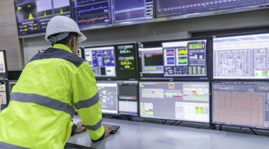Kontrol odasında çalışan bir mühendis. Yönetici kontrol sistemi. Birçok monitörden teknisyen izleme programı