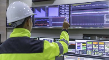 Kontrol odasında çalışan bir mühendis. Yönetici kontrol sistemi. Birçok monitörden teknisyen izleme programı