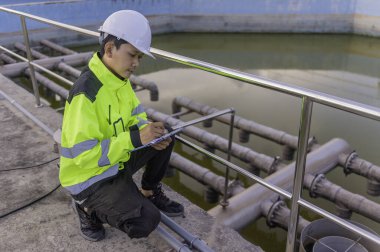 Çevre mühendisi atık su arıtma tesislerinde çalışıyor. Su geri dönüşüm tesisinde tekrar kullanılmak üzere çalışan su tedarik mühendisliği