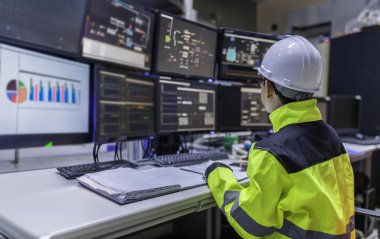 Büyük Endüstri Fabrikası Kadın Bilgisayar Mühendisi Kişisel Bilgisayar 'da çalışıyor. Kontrol makinesi için program kodluyor. Taylandlılar dört monitörle çalışıyorlar. Ciddi ile çalışan programcı