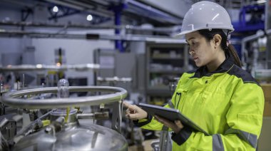 Ameliyathanede çalışan Asyalı mühendis. Taylandlılar kask takar. Adam özenle ve sabırla çalışmış, kadın hidrojen tankındaki valf düzenleyicisini kontrol etmiş..