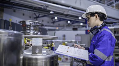 Ameliyathanede çalışan Asyalı mühendis. Taylandlılar kask takar. Çalışkanlık ve sabırla çalıştı, hidrojen tankındaki kapakçık düzenleyicisini kontrol etti..
