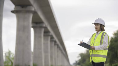 Otoyol köprüsü inşaatında çalışan Asyalı bir kadın mühendis. Sınır ötesi inşaatı denetleyen memur.