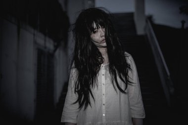 Asyalı kadın portresi kanla kaplanmış hayalet yüzü. Korku sahnesi. Ürkütücü bir geçmiş. Cadılar Bayramı posteri. Taylandlılar.