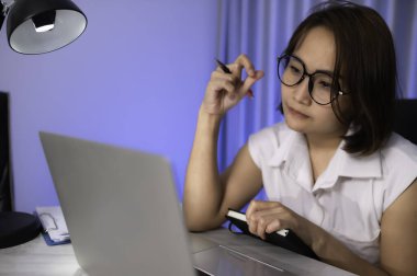 Güzel Asyalı kadın gece evde çalışıyor. Şirketten bir sürü iş, eve iş getirmek. Ev kavramından çalış. Çok çalışmaktan yoruldum.