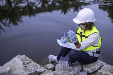 Çevre mühendisi su kalitesini inceliyor. Test için laboratuvara su getirin. Su ve topraktaki mineralleri kontrol et. Su kaynaklarındaki kirleticileri kontrol et.