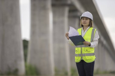 Otoyol köprüsü inşaatında çalışan Asyalı bir kadın mühendis. Sınır ötesi inşaatı denetleyen memur.