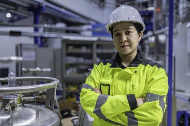 Ameliyathanede çalışan Asyalı mühendis. Taylandlılar kask takar. Adam özenle ve sabırla çalışmış, kadın hidrojen tankındaki valf düzenleyicisini kontrol etmiş..