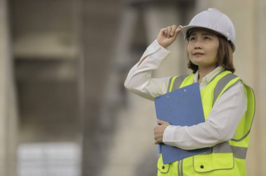 Otoyol köprüsü inşaatında çalışan Asyalı bir kadın mühendis. Sınır ötesi inşaatı denetleyen memur.