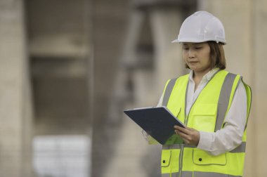 Otoyol köprüsü inşaatında çalışan Asyalı bir kadın mühendis. Sınır ötesi inşaatı denetleyen memur.