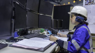 Büyük Endüstri Fabrikası Kadın Bilgisayar Mühendisi Kişisel Bilgisayar 'da çalışıyor. Kontrol makinesi için program kodluyor. Taylandlılar dört monitörle çalışıyorlar. Ciddi ile çalışan programcı